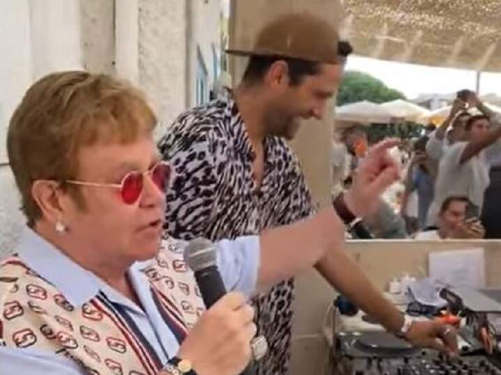 Elton John aparece ao lado do DJ, em um restaurante na França, onde apresentou sua nova música aos clientes